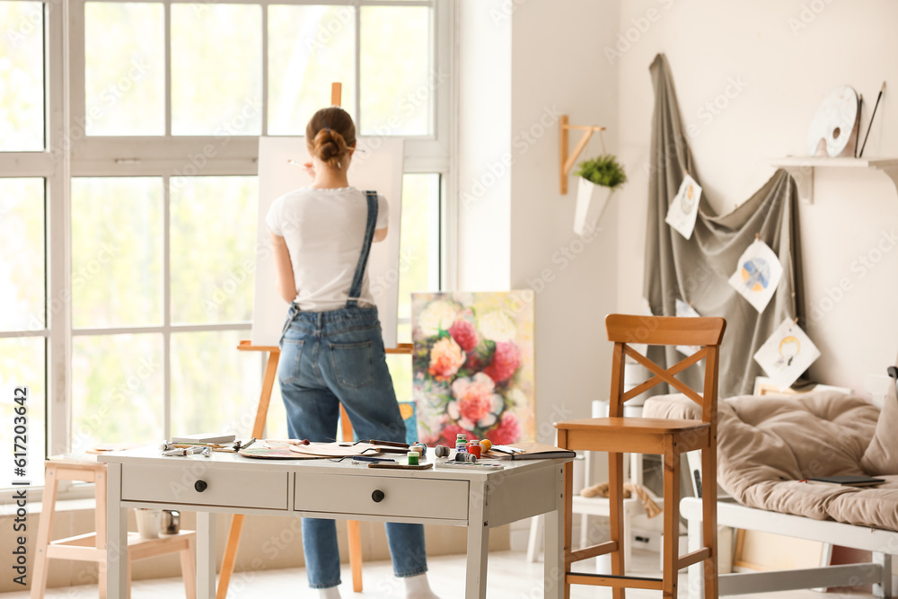 Female artist painting picture in workshop Female artist painting picture in workshop