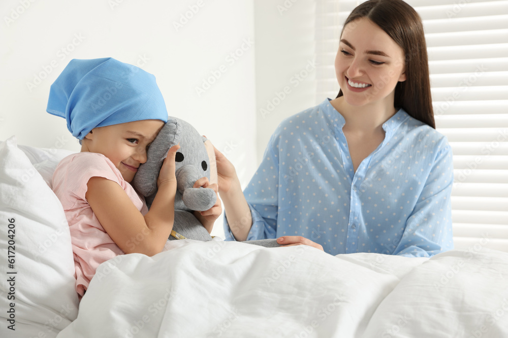 Childhood cancer. Mother and daughter with toy elephant in hospital Childhood cancer. Mother and daughter with toy elephant in hospital