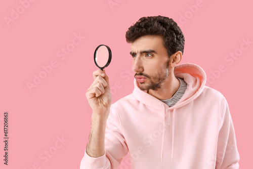 Young man with magnifier on...