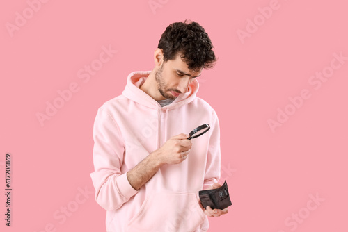 Young man with magnifier an...