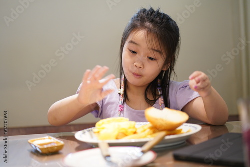 Young asian girl enjoy eating burger and french fries