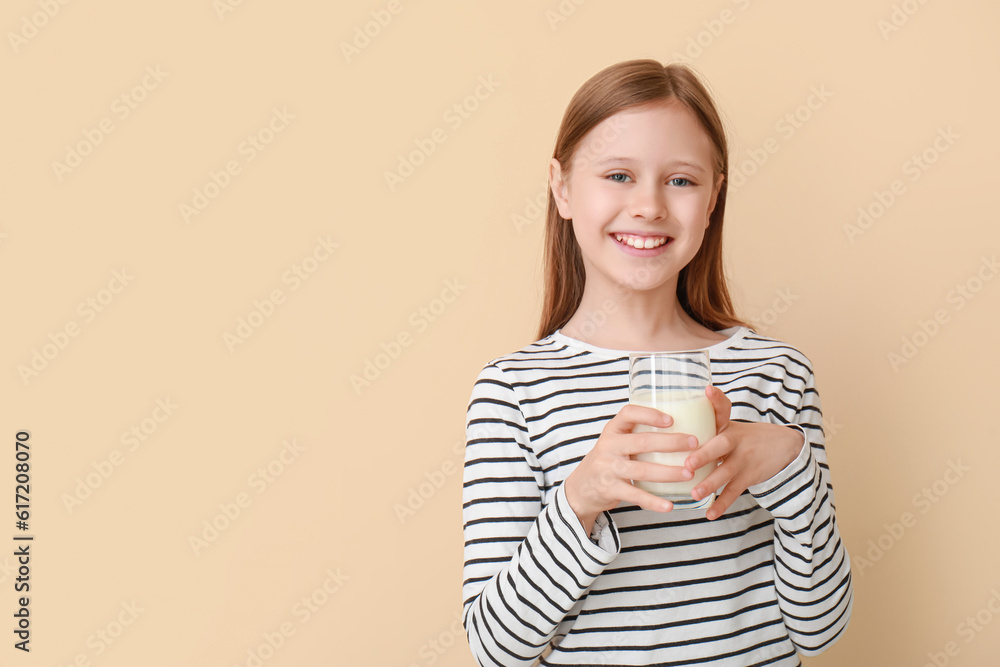 Little girl with glass of milk on beige background Little girl with glass of milk on beige background