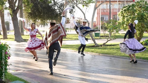 mixed group of four people dressed as huaso dancing cueca in the town square photo