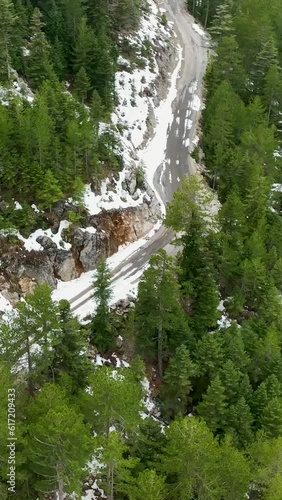 Vertical Video: Above the Snow-Covered Turkish Forest - Aerial View of Winter Mountain Landscape with River and Cinematic Waterfalls photo