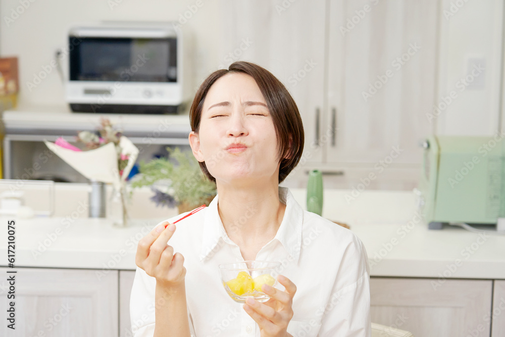 ダイニングでパイナップルを食べる女性 ダイニングでパイナップルを食べる女性