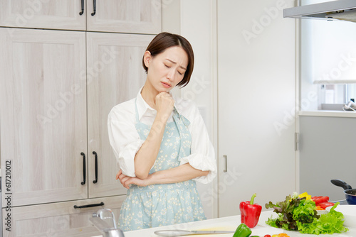キッチンで悩むミドルエイジ女性