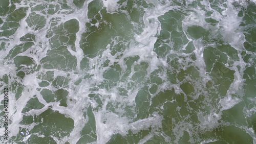 Overhead view of waves crashing on sandy beach