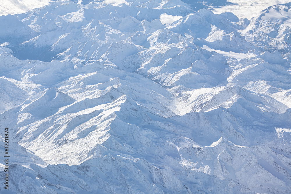 View from the plane on the snowy mountains of the Alps View from the plane on the snowy mountains of the Alps