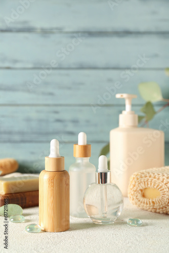 Cosmetic dropper bottles on color background