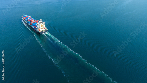 Aerial stern view of cargo maritime ship with contrail in the ocean ship carrying container and running for export concept technology freight shipping by ship forwarder mast © Yellow Boat