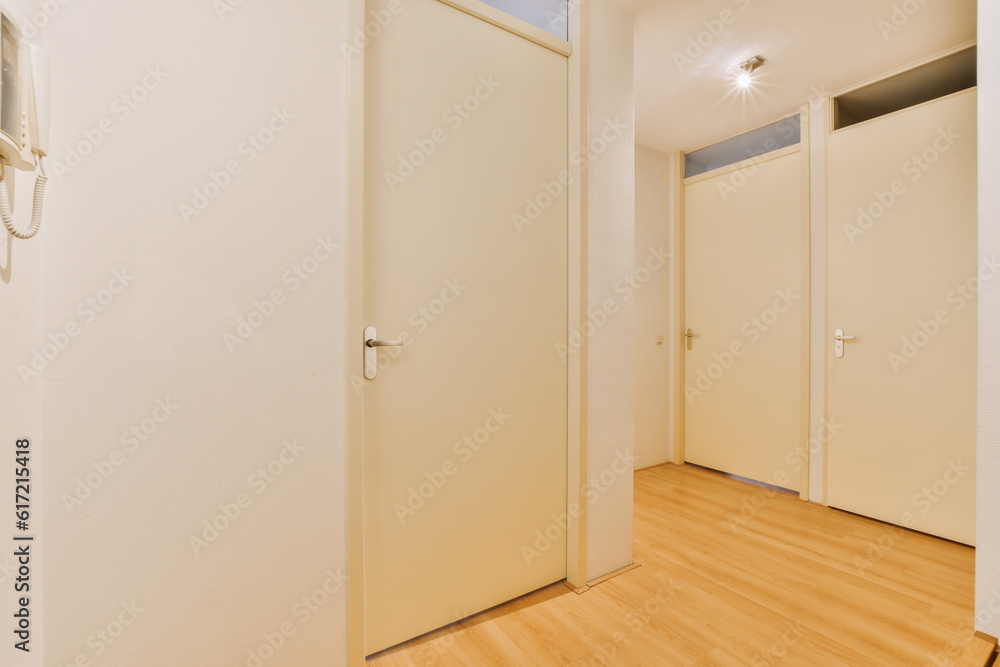 an empty room with wooden floors and white doors on either side, one door open to the other is closed an empty room with wooden floors and white doors on either side, one door open to the other is closed