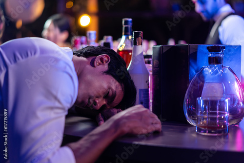Asian depression man feeling heart broken and drinking beer in a bar. 