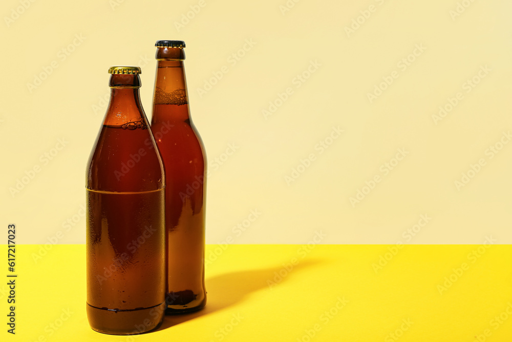 Bottles of cold beer on yellow background Bottles of cold beer on yellow background