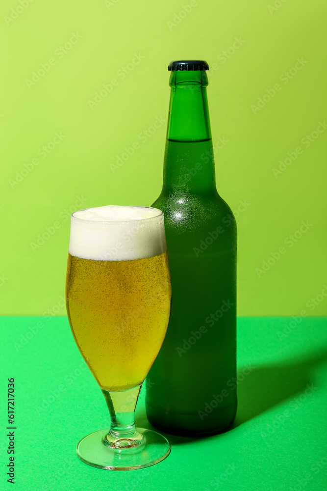 Bottle and glass of cold beer on green background Bottle and glass of cold beer on green background