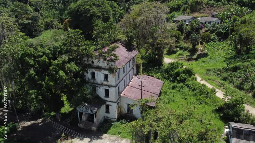 Nature fighting back old dilapidated 3-story building with red rusted roof plants slow growing in and around building camera slow moving around building aerial Video Nature fighting back old dilapidated 3-story building with red rusted roof plants slow growing in and around building camera slow moving around building aerial Video