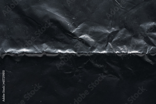 Wrinkled black plastic bag texture, macro close up.