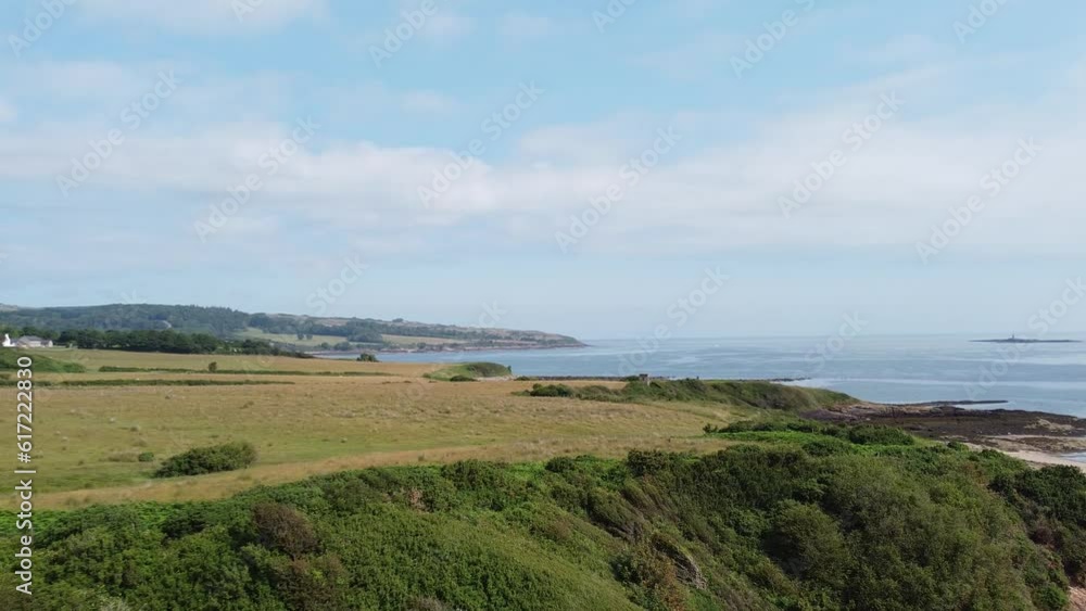 Traeth Lligwy Anglesey eroded coastal shoreline establishing aerial view over scenic green rolling Welsh weathered coastline