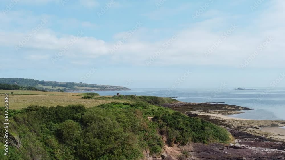 Traeth Lligwy Anglesey coastal shoreline aerial view dolly across scenic Welsh weathered coastline Traeth Lligwy Anglesey coastal shoreline aerial view dolly across scenic Welsh weathered coastline