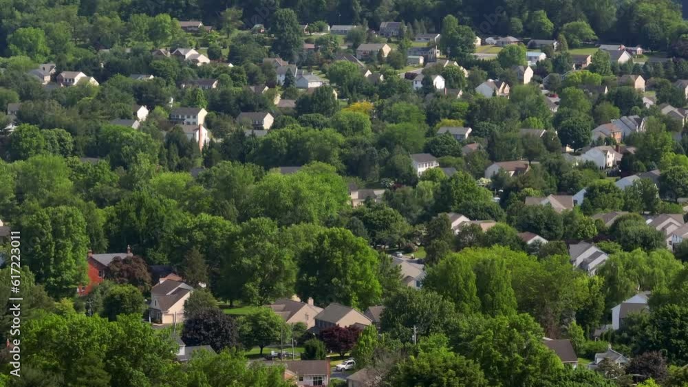 A drone aerial of homes hidden amongst trees in American town. Housing development shot with long aerial zoom lens. A drone aerial of homes hidden amongst trees in American town. Housing development shot with long aerial zoom lens.