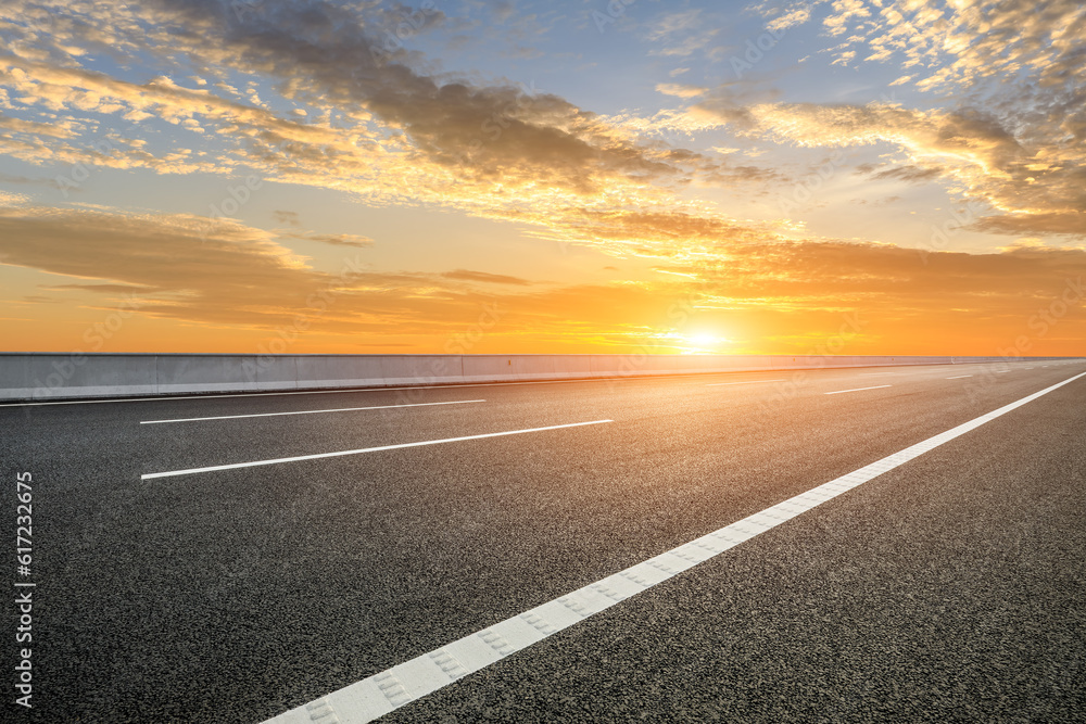 Naklejka premium Asphalt road and sky clouds at sunset
