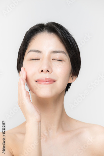 Close-up of the beauty image of skin care and esthetics for bare skin, such as moisturizing and drying of the eyes and cheeks of beautiful Asian women.