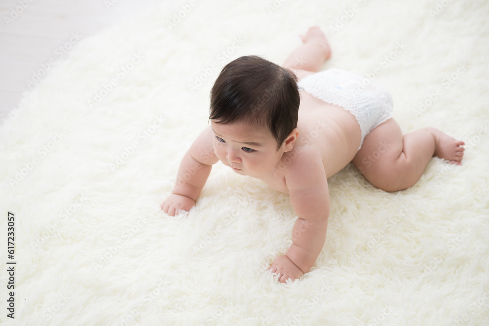 Overhead view of a cute baby with diaper-wearing, topless, chewy body in backlight Photocopy space available Overhead view of a cute baby with diaper-wearing, topless, chewy body in backlight Photocopy space available
