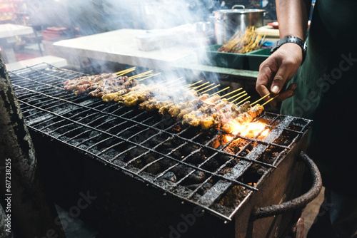 Grilling chicken satay photo