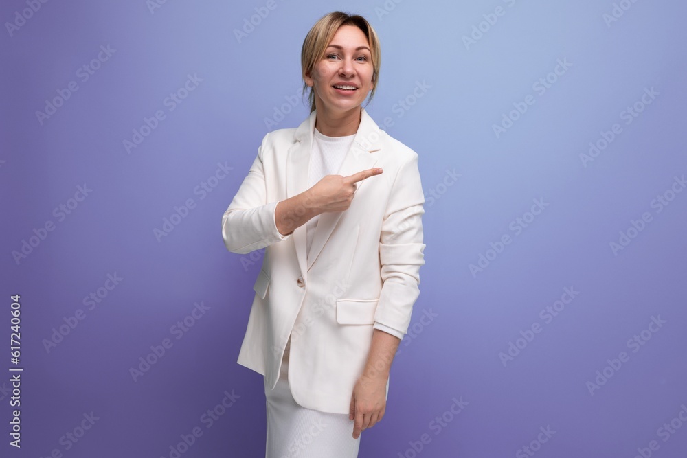 pretty slender young blond business leader woman in a white jacket points her finger towards the wall with inspiration pretty slender young blond business leader woman in a white jacket points her finger towards the wall with inspiration
