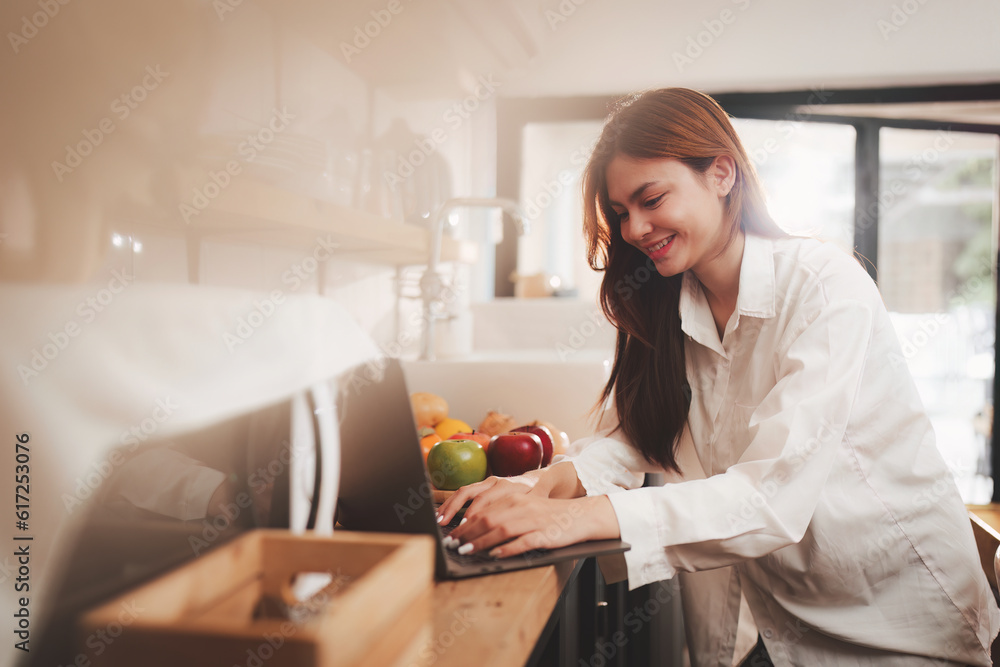 Portrait of a young cheerful asian woman at kitchen room with healthy raw food. Vegetarianism, wellbeing and healthy lifestyle concept Portrait of a young cheerful asian woman at kitchen room with healthy raw food. Vegetarianism, wellbeing and healthy lifestyle concept