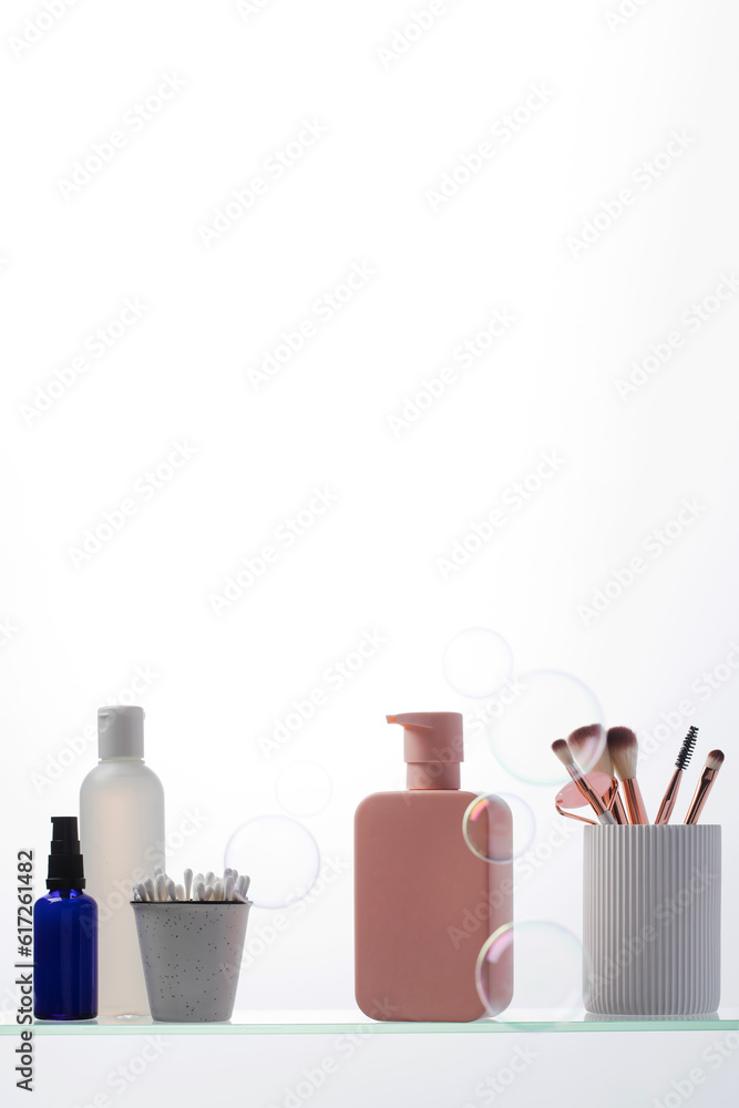 A set of cosmetics for the care and youth of the skin on a glass shelf. Layouts with a place for your logo. A set of cosmetics for the care and youth of the skin on a glass shelf. Layouts with a place for your logo.