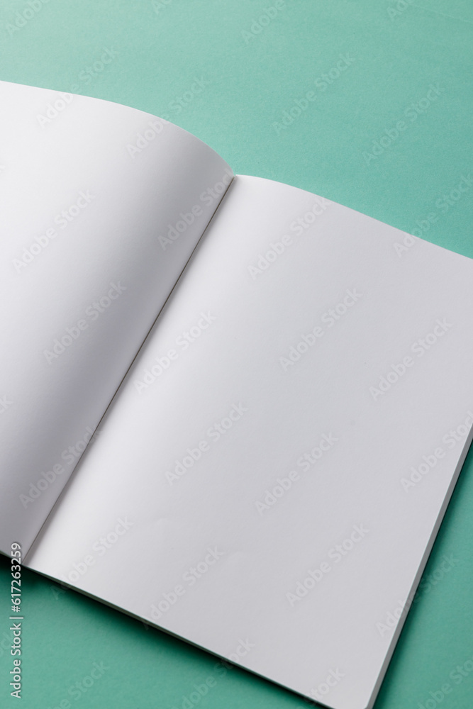 Close up of open book with copy space on green background Close up of open book with copy space on green background