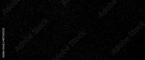 Flying dust particles on a black background, black glitter texture sparkling festive glowing shiny wrapping paper background.