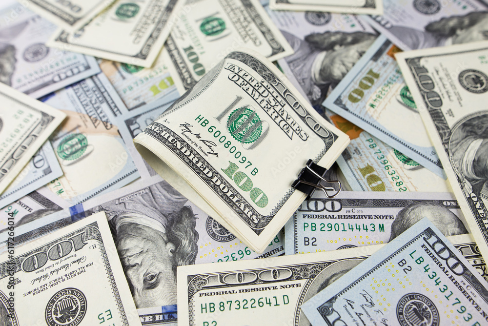 One hundred dollars close-up in large quantities lie on the table. Much money. One hundred dollars close-up in large quantities lie on the table. Much money.