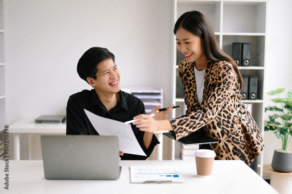 Two Asian business man and woman workers talking on the smartphone and using laptop Professionals in Teamwork Finance, Marketing, and Success Two Asian business man and woman workers talking on the smartphone and using laptop Professionals in Teamwork Finance, Marketing, and Success