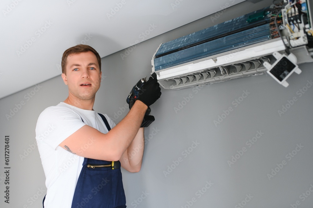 Technician repairing air conditioner on the wall