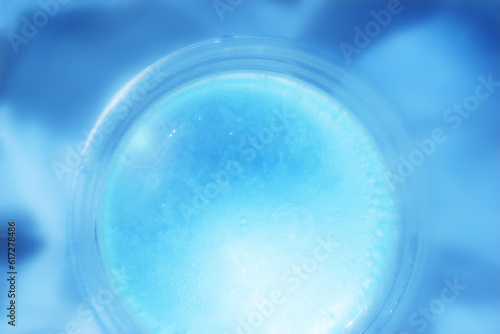 Abstract Defocus blue tiny water bubble in transparent plastic cup. Abstract premium blue backdrop banner for advertise commercial, cosmetic skincare and consumers products.