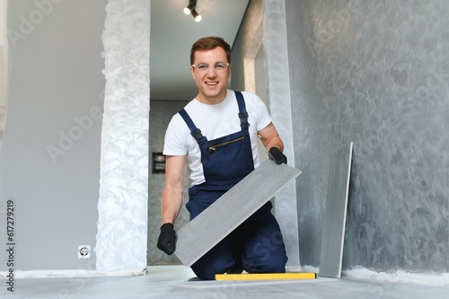фотографія industrial worker, handyman installing ceramic tiles.