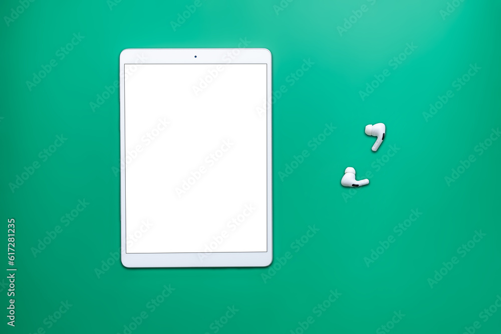 technology tablet, headphones, pencil on neutral green background with cardboard texture technology tablet, headphones, pencil on neutral green background with cardboard texture