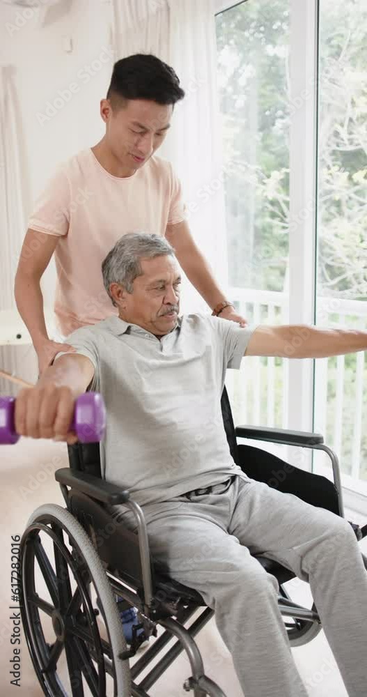 Vertical video of diverse male physiotherapist and senior male patient exercising, in slow motion Vertical video of diverse male physiotherapist and senior male patient exercising, in slow motion
