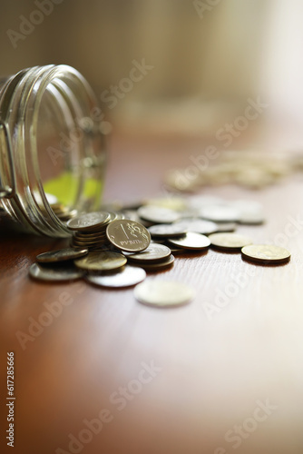 Russian rubles and metal coins inside a glass jar close-up on black blurred background