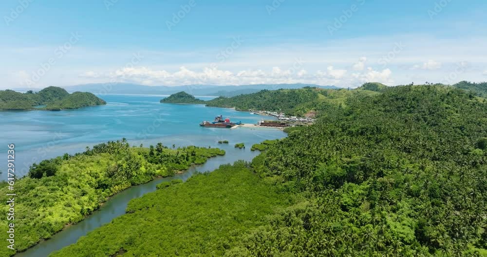 Air survey of sea port with cargo ship in tropical island. Mindanao, Philippines. Air survey of sea port with cargo ship in tropical island. Mindanao, Philippines.