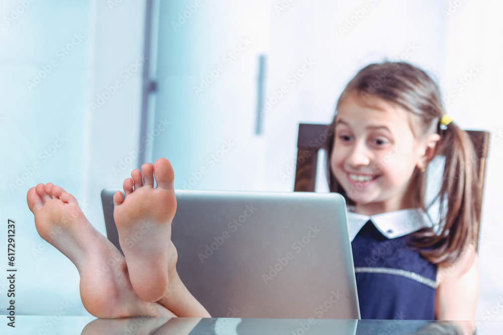 Humorous image of cheerful caucasian young girl took off her shoes, put her feet on the desktop and working in office with bare feet. Selective focus on feet. Horizontal image. Humorous image of cheerful caucasian young girl took off her shoes, put her feet on the desktop and working in office with bare feet. Selective focus on feet. Horizontal image.