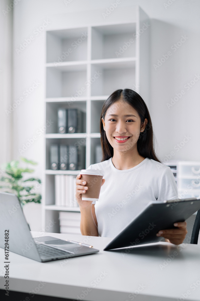 Female asian sitting at the desk, looking to camera. Female asian sitting at the desk, looking to camera.