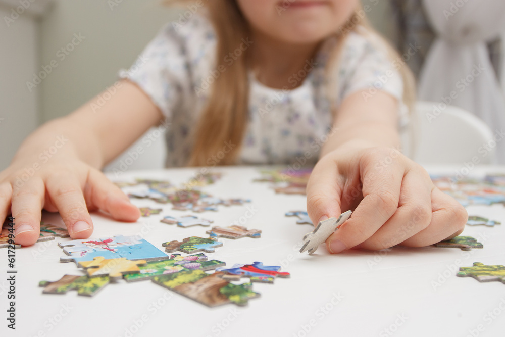 Little child picks up picture from pieces of puzzles Little child picks up picture from pieces of puzzles