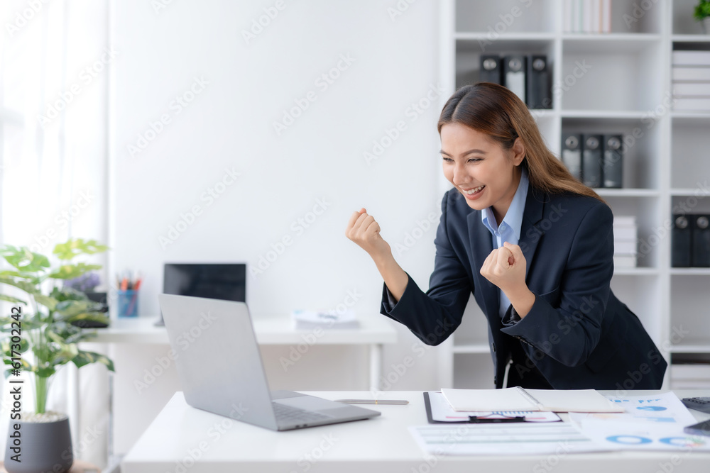 Happy asian businesswoman raising hands with victory smiling happily with laptop computer. The concept of success at work. Happy asian businesswoman raising hands with victory smiling happily with laptop computer. The concept of success at work.