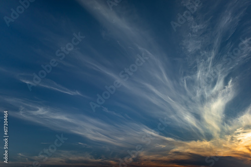 Cirrus cloud in the sky against the blue sky and sunset. Natural sky background