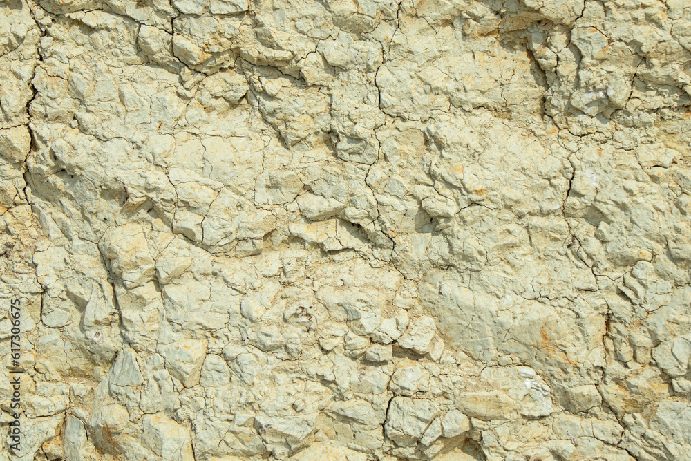 White clay with cracks close-up. Natural ground background on a sunny day
