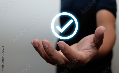 hand holding white check mark, check mark, tick icon, check mark, white circle mark button Made on a gray background. Banner. Copy space. text area