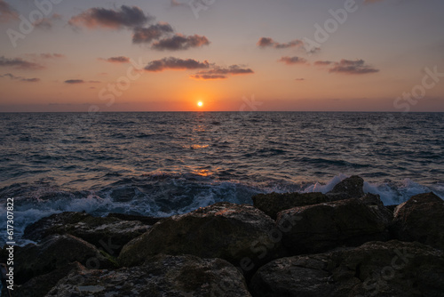 sunset on the seashore with a sandy steep shore.