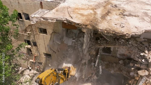 Excavator arm demolishing an old building, Aerial view